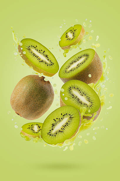 Fresh kiwi juice with freshly cut kiwi fruit slices in dynamic splashes soar as flow on green background. Great for summer detox menu, vitamin product promotion, antioxidant beverage, juice label.
