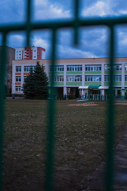 istock Urban school and exercise yard in Minsk viewed through fence bars 2253708844