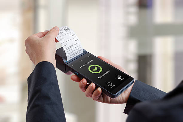 istock Customer holding portable POS terminal with printed receipt and approved payment screen, representing successful checkout, retail transaction completion, and modern electronic payment systems 2253709035