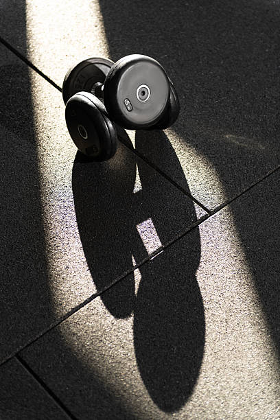 istock Close Up Stacked 5kg Dumbbells in Dappled Sunlight 2253713865