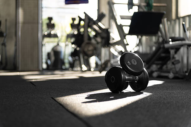 istock Close Up Stacked 5kg Dumbbells in Dappled Sunlight 2253713916