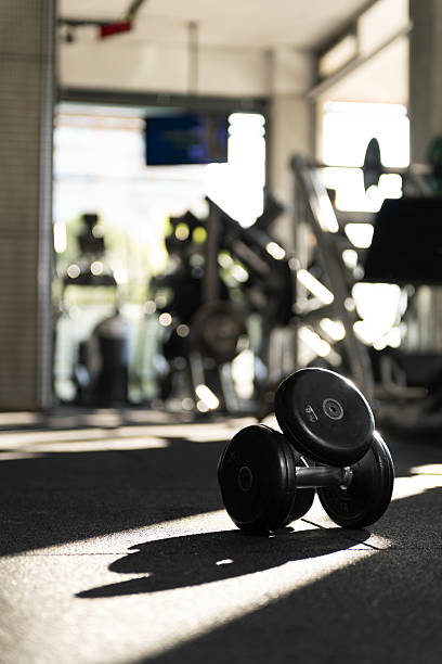 istock Close Up Stacked 5kg Dumbbells in Dappled Sunlight 2253713953