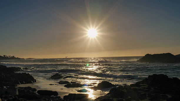 istock Dramatic Ocean Sunset with Sunburst Over Rocky Coast 2253723707