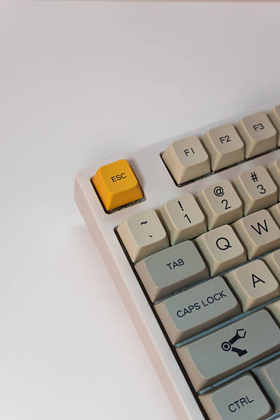 istock White mechanical keyboard with bright yellow Esc key on white background, minimalism, keyboard buttons. A keyboard with a yellow key and red volume button 2253724030