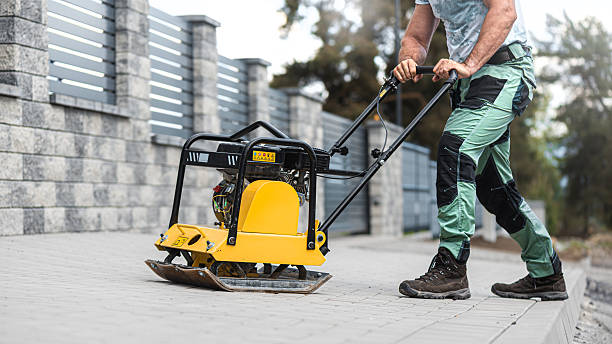 istock Working with vibro-compaction plate to compact self-locking blocks in their laying bed. Vibrating plate in construction. 2253727971
