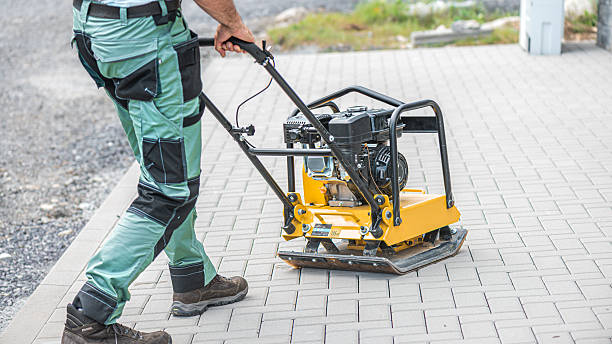 istock Working with vibro-compaction plate to compact self-locking blocks in their laying bed. Vibrating plate in construction. 2253727987