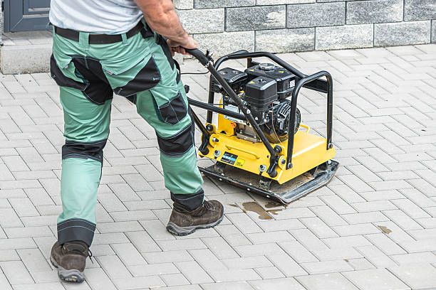 istock Working with vibro-compaction plate to compact self-locking blocks in their laying bed. Vibrating plate in construction. 2253728076