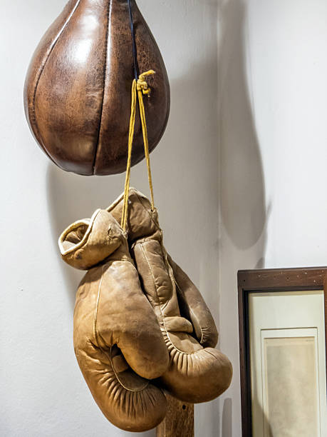 Old worn leather brown boxing gloves and boxing bag