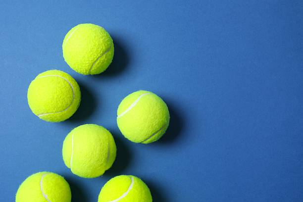 istock Tennis balls on blue background 2253732439