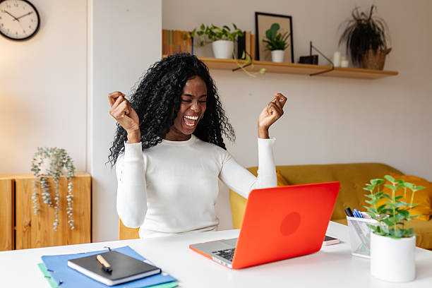 istock Excited young black woman celebrating success while working from home 2253732585