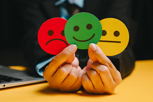 istock Feedback concept. Happy face, sad face, neutral face held by hands showing emotion choice and feedback concept in office setting 2253732616