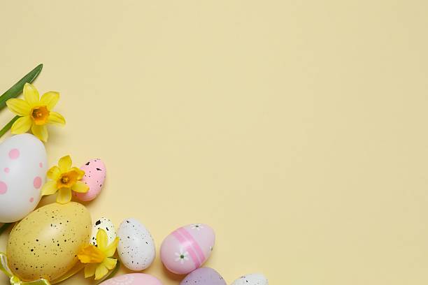 istock Happy Easter. Colorful eggs and yellow flowers on color background, space for text or advertising 2253732693
