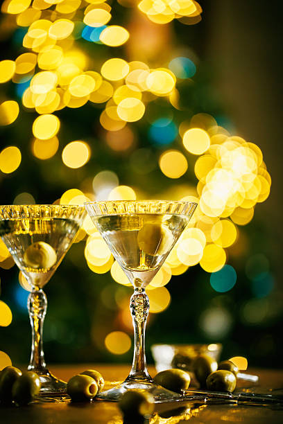 istock Two martini glasses with olives and holiday lights 2253732946