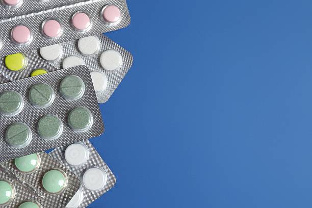 istock Pills in blister packs on blue background, close up 2253732970