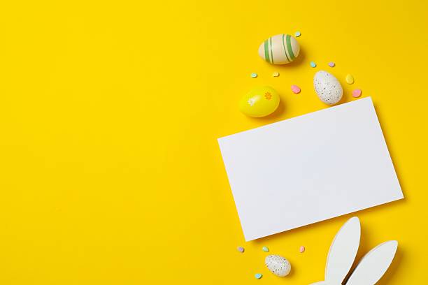 istock Happy Easter. Colorful eggs, paper card with bunny ears on color background, space for text or advertising 2253733154