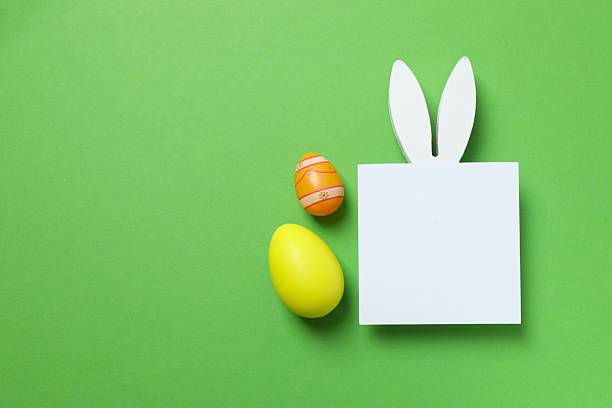 istock Happy Easter. Colorful eggs, paper card with bunny ears on color background, space for text or advertising 2253733195