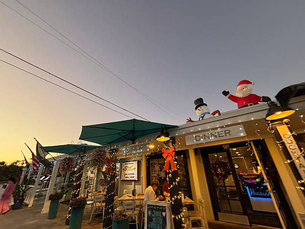 Sanibel, Florida, United States of America - December 22, 2025: Sanibel, Florida restaurant celebrating the Christmas season with festive inflatable Santa Claus and snowman decorations on the roof, attracting customers on Periwinkle Way during dusk