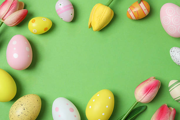 istock Happy Easter. Colorful eggs with tulips on green background, space for text or advertising 2253733519