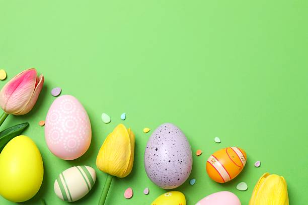 istock Happy Easter. Colorful eggs with tulips on green background, space for text or advertising 2253733558