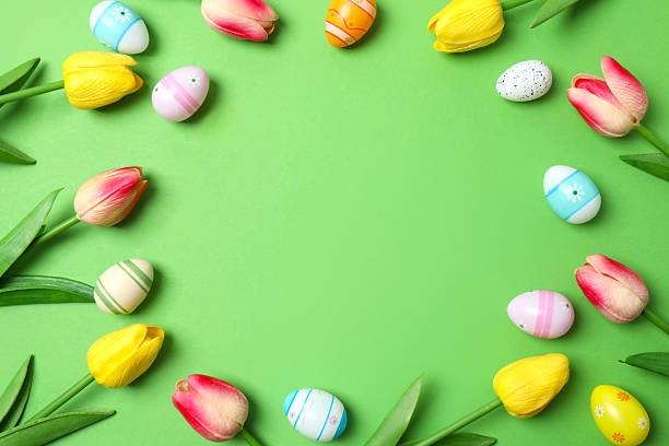 istock Happy Easter. Colorful eggs with tulips on green background, space for text or advertising 2253733618