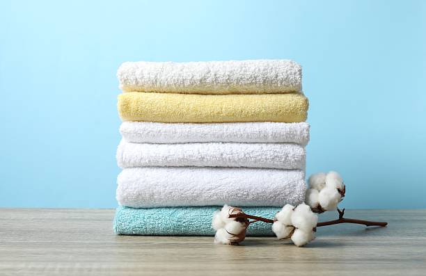 istock Stack of bath towels with cotton flowers on the table 2253734800