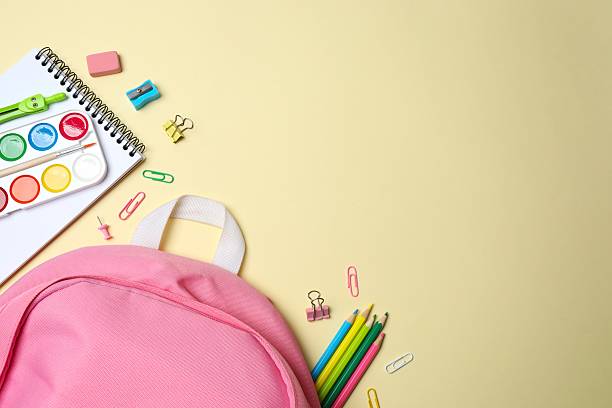 istock Pink backpack with school supplies on beige background. Top view, space for text 2253735441