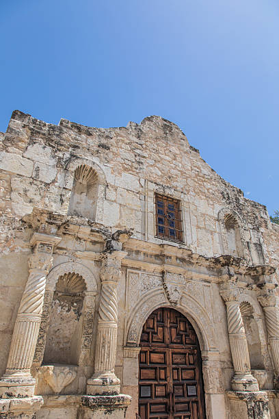 Wide angle photo of the front wall of the Alamo against a blue sky in San Antonio, Texas