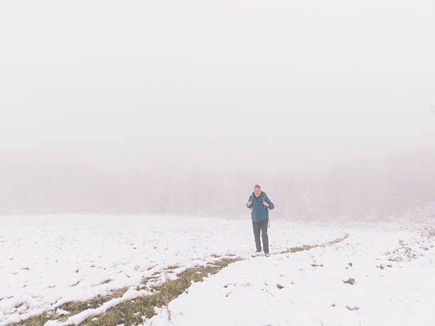 Man enjoy winter walk in nature in snowy fog mountain