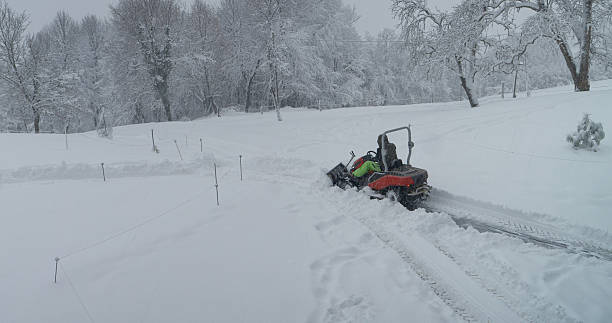 istock Person operating a small tractor with plow to remove deep blanket of fresh snow 2253743607
