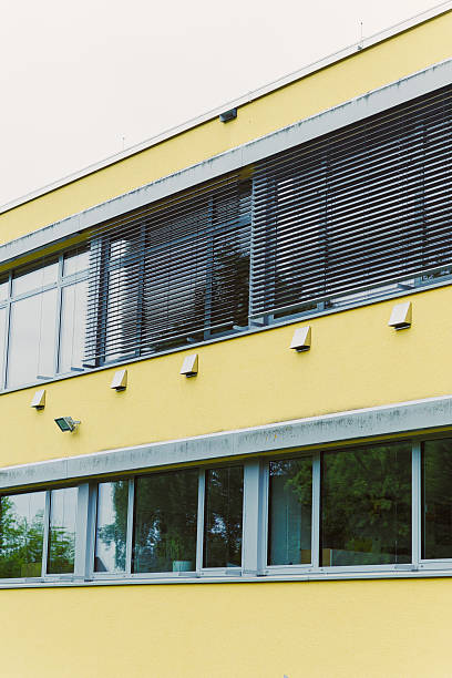 istock This contemporary architecture features a striking yellow building with uniquely textured walls and large, inviting windows, enhancing its overall design and creating impressive visual appeal 2253743614