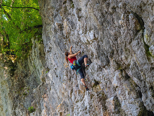 istock Focused female climber reaches for next hold on a limestone wall 2253743628
