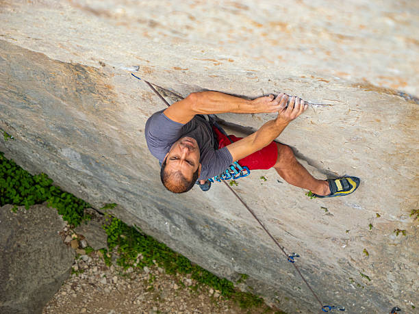istock CLOSE UP, TOP DOWN: Focused male climber battles up a steep limestone route 2253743639
