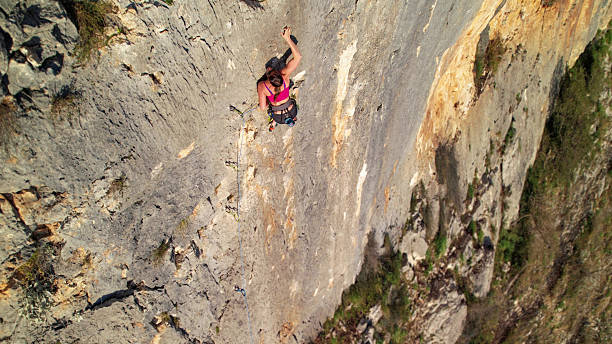 istock AERIAL: View above a brave female climber high on an exposed limestone face 2253743689