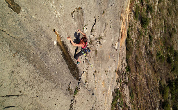 istock AERIAL, CLOSE UP: Agile female climber works her way up a tall limestone wall 2253743696