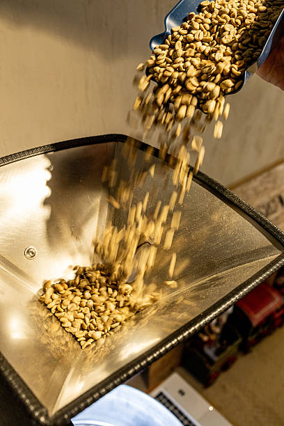 istock Green Coffee Beans Pouring Into Roaster 2253744080