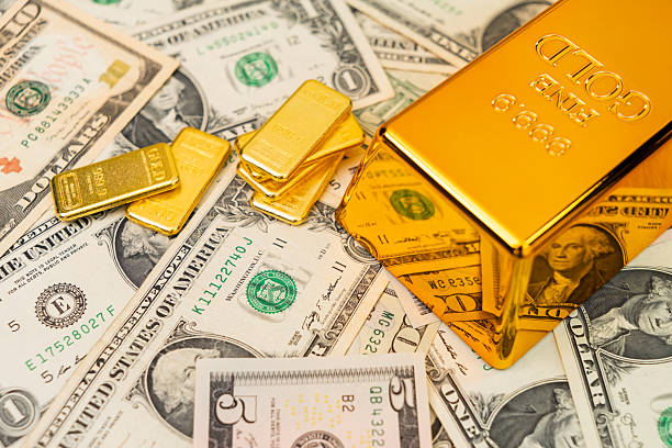 Different gold bars placed on a US dollar bills symbolizing wealth, investment, inflation hedge, and financial security in uncertain markets.