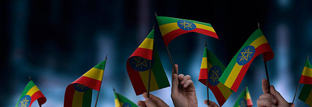 Ethiopia flags in their hands on a blurred urban background. The photo illustration was created without the use of artificial intelligence, only using Photoshop.