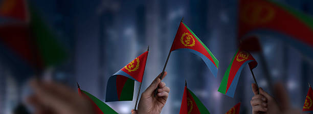 istock Eritrea flags in their hands on a blurred urban background 2253757467
