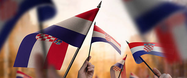 istock Croatia flags in their hands on a blurred urban background 2253757546