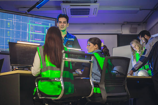 Young security worker talking by the telephone in security room