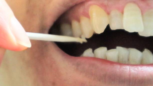 istock A person cleaning the gaps between their teeth with a toothpick 2253761961