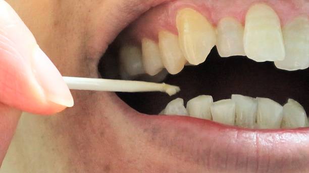 istock A person cleaning the gaps between their teeth with a toothpick 2253761965