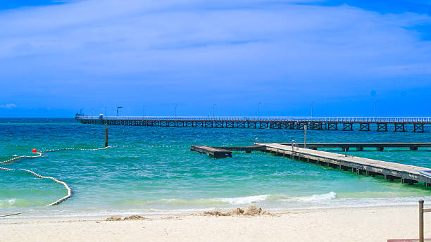 istock Wooden Pier Stretching Over Turquoise Ocean Under Clear Blue Sky 2253762570
