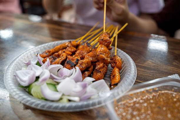 Grilled Chicken Satay Skewers Served with Fresh Cucumber and Onion