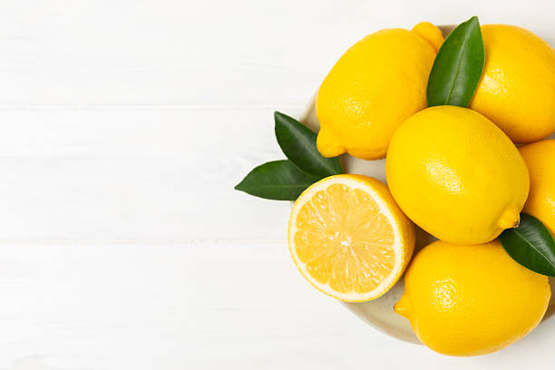 istock Lemon on a wooden table. Fresh lemon with a slice. Fresh lemon with citrus leaves. Lemon juice. Food and drink ingredients preparing. Healthy eating. Vitamin C. Space for text. 2253764458