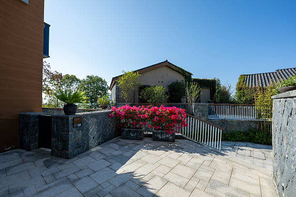 Large, bright, medieval house decorated with palm trees, shrubs and flowers.