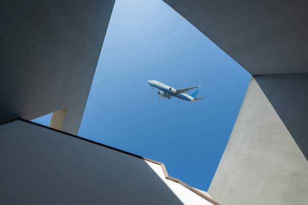 istock Looking up at modern architectural shapes to see airplanes 2253765850