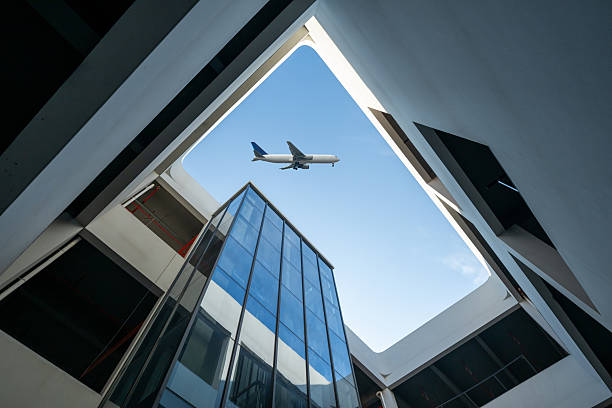 istock Looking up at modern architectural shapes to see airplanes 2253765851