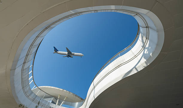 istock Looking up at modern architectural shapes to see airplanes 2253765852