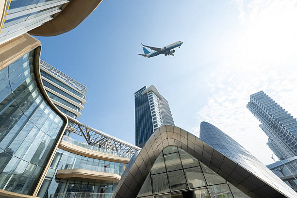 istock Looking up at modern office buildings, watching planes fly by 2253765857